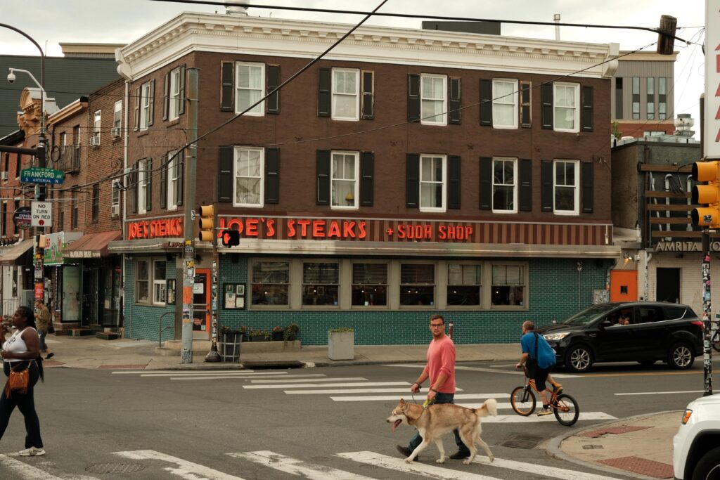 Corner of Girard and Frankford Avenue in Fishtown, Philadelphia, featuring Joe’s Steak Diner and pedestrians walking by