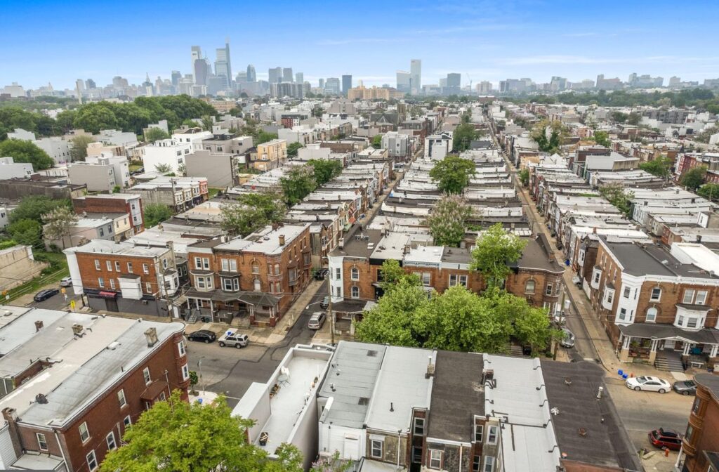 Aerial view of Brewerytown, Philadelphia, showing a mix of historic rowhomes, modern residential buildings, and tree-lined streets with the city skyline visible in the distance