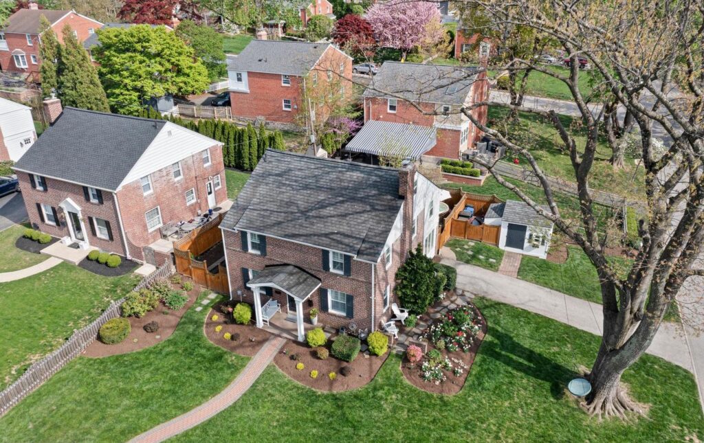 Aerial view of a quiet residential street in Bryn Mawr, PA, featuring classic brick homes with landscaped yards, mature trees, and spacious lawns in a charming Philadelphia Main Line neighborhood.
