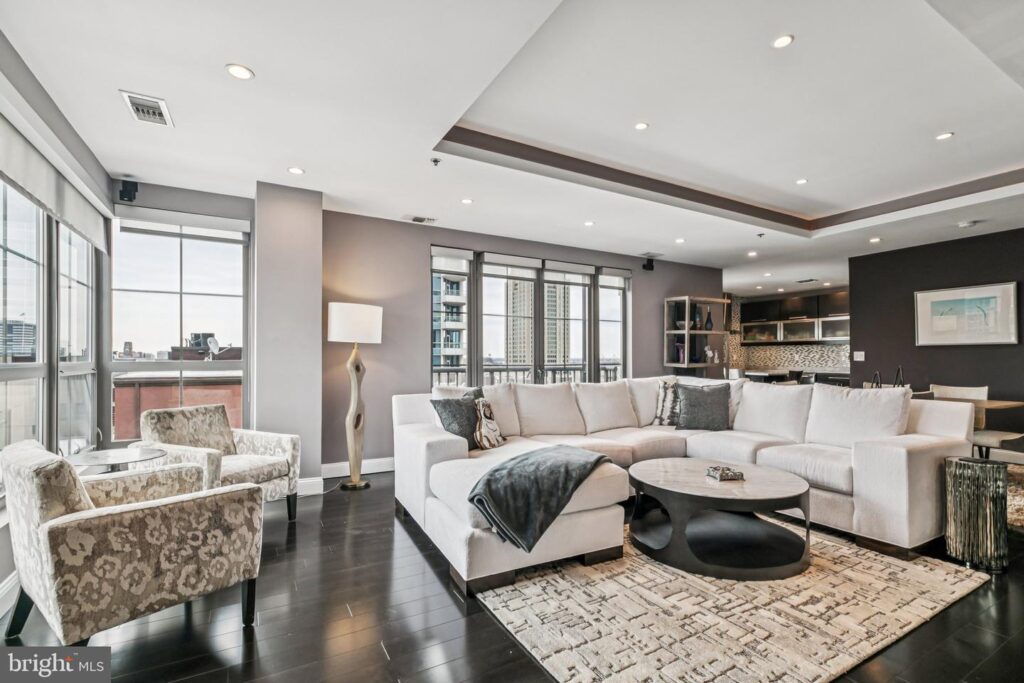 Interior of Unit 605 at The Moravian featuring an open-concept living area with floor-to-ceiling windows, dark hardwood floors, and modern upscale finishes.
